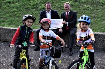 Dr. Hendrik Ziegenbein, Vorstand der Sparkasse Gera-Greiz, überreichte im Beisein des jüngsten Radsport-Nachwuchses einen symbolischen Spendenscheck an SSV-Präsident Olaf Albrecht.