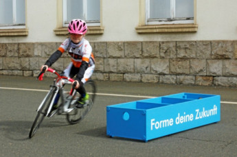 Helene Franke, 7-jährige Nachwuchs-Radfahrerin und Teilnehmerin bei der Ostthüringer Tour zeigt mit ihrem Rad auf dem Werksgelände der Silbitz Group einige Übungen.   (Foto:&nbsp;Larissa&nbsp;König)